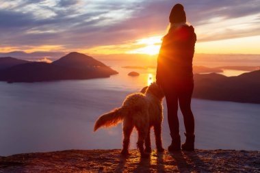 Maceracı Kız bir köpekle dağın tepesinde yürüyüş yapıyor.