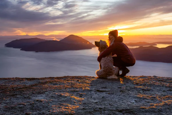 Maceracı Kız bir köpekle dağın tepesinde yürüyüş yapıyor.
