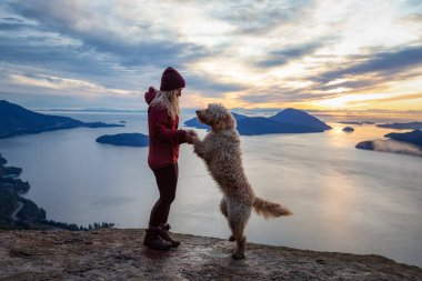 Maceracı Kız bir köpekle dağın tepesinde yürüyüş yapıyor.