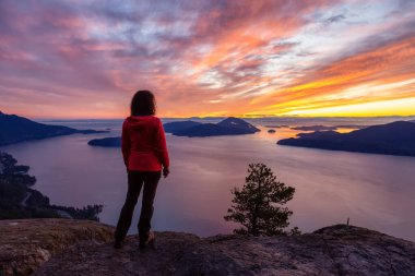 Bir dağın tepesinde duran maceraperest beyaz kız