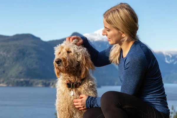 Chica aventurera Senderismo en la cima de una montaña con un perro — Foto de Stock