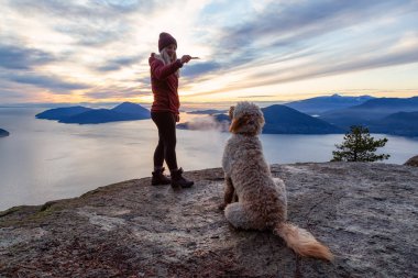 Maceracı Kız bir köpekle dağın tepesinde yürüyüş yapıyor.