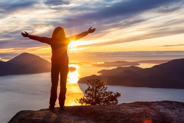 Äventyrlig vit flicka står på toppen av ett berg — Stockfoto