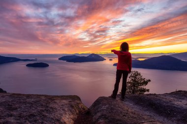 Bir dağın tepesinde duran maceraperest beyaz kız