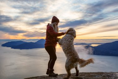 Maceracı Kız bir köpekle dağın tepesinde yürüyüş yapıyor.