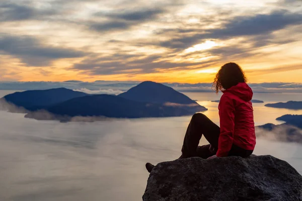 Chica aventurera en la cima de una montaña durante la puesta del sol — Foto de Stock