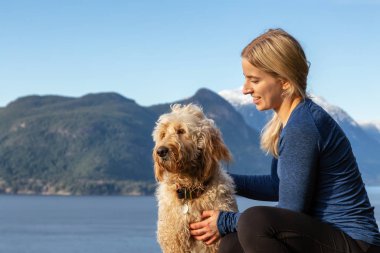 Maceracı Kız bir köpekle dağın tepesinde yürüyüş yapıyor.