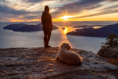 Maceracı Kız bir köpekle dağın tepesinde yürüyüş yapıyor.