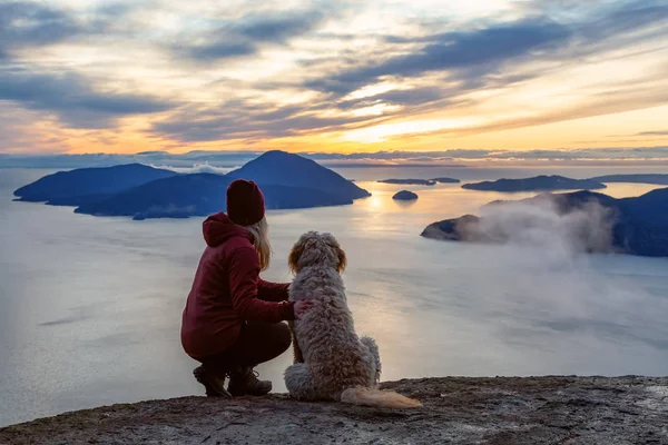 Adventurosa menina Caminhadas no topo de uma montanha com um cão — Fotografia de Stock