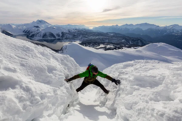 Homem aventureiro Subir uma montanha de neve íngreme — Fotografia de Stock