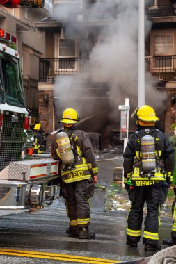 İtfaiyeciler bir ev yangınına müdahale ediyorlar.