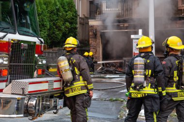 İtfaiyeciler bir ev yangınına müdahale ediyorlar.