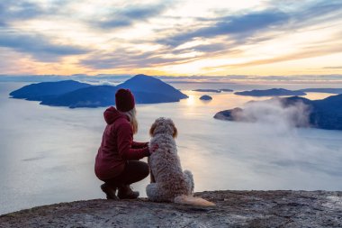 Maceracı Kız bir köpekle dağın tepesinde yürüyüş yapıyor.