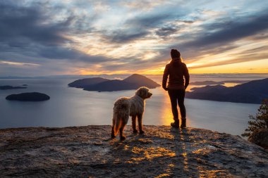 Maceracı Kız bir köpekle dağın tepesinde yürüyüş yapıyor.