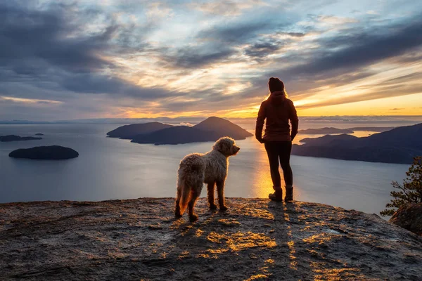 Maceracı Kız bir köpekle dağın tepesinde yürüyüş yapıyor.