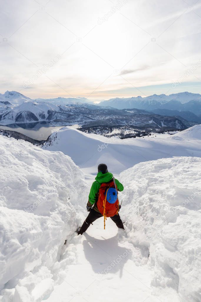 Adventurous man Climbing up a steep snowy mountain