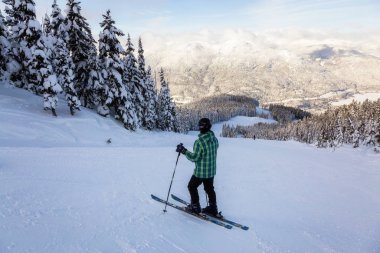 Whistler, British Columbia, Kanada - 17 Ocak 2020: Canlı ve güneşli bir kış gününde güzel bir karlı dağda Maceracı Kız Kayak.
