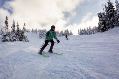 Whistler, British Columbia, Kanada - 17 Ocak 2020: Canlı ve güneşli bir kış gününde güzel bir karlı dağda Maceracı Kız Kayak.