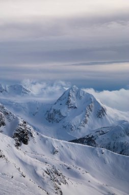 Whistler, British Columbia, Kanada. Kanada Karlı Dağ manzarasının güzel panoramik manzarası bulutlu ve canlı kış günbatımında.