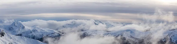 ウィスラー ブリティッシュコロンビア州 カナダ 曇りで活気に満ちた冬の日没の間のカナダの雪に覆われた山の風景の美しいパノラマビュー — ストック写真