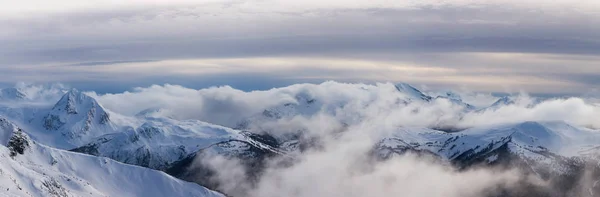 ウィスラー ブリティッシュコロンビア州 カナダ 曇りで活気に満ちた冬の日没の間のカナダの雪に覆われた山の風景の美しいパノラマビュー — ストック写真