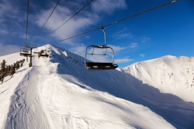 Kicking Horse, Golden, British Columbia, Kanada. Kışın canlı, güneşli ve bulutlu bir sabah gündoğumunda Güzel Kanada Dağına giden bir teleferik..