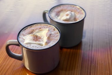 Tahta bir masada kremalı sıcak çikolata..