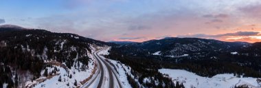 Renkli bir kış gündoğumu sırasında Kanada Dağ Manzarası 'ndan geçen manzaralı bir otobanın hava panoramik görüntüsü. Hope ve Merritt yakınlarında çekildi, British Columbia, Kanada.