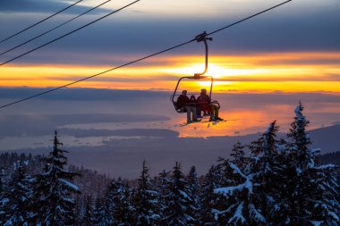 Seymour Dağı, Kuzey Vancouver, Britanya Kolumbiyası, Kanada - 10 Şubat 2020 - Güneşli ve bulutlu kış günbatımında bir kayak merkezinin tepesine çıkmak.