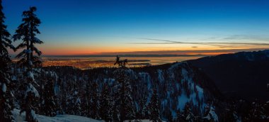 Renkli ve canlı kış günbatımında arka planda şehirle birlikte Kanada Doğa Alanı taze beyaz karla kaplıydı. Seymour Dağı, Kuzey Vancouver, British Columbia, Kanada 'da çekildi. Panorama