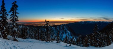 Renkli ve canlı kış günbatımında arka planda şehirle birlikte Kanada Doğa Alanı taze beyaz karla kaplıydı. Seymour Dağı, Kuzey Vancouver, British Columbia, Kanada 'da çekildi. Panorama