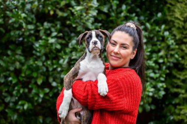 Bahçesinde küçük şirin bir boksör köpeği olan beyaz, beyaz bir kız. Vancouver, British Columbia, Kanada 'da çekildi..