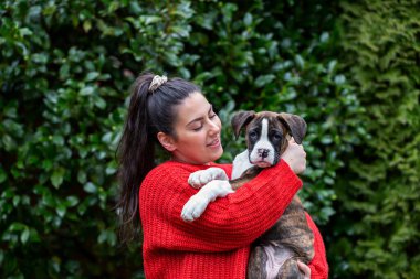 Bahçesinde küçük şirin bir boksör köpeği olan beyaz, beyaz bir kız. Vancouver, British Columbia, Kanada 'da çekildi..