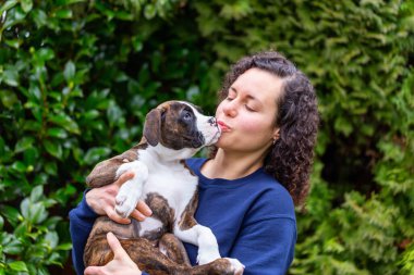 Bahçesinde küçük şirin bir boksör köpeği olan beyaz, beyaz, beyaz bir kadın. Vancouver, British Columbia, Kanada 'da çekildi..