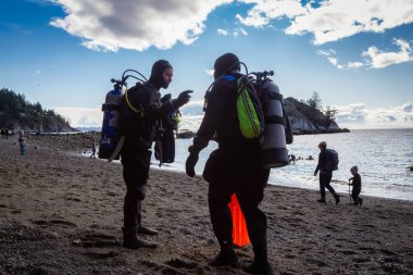 Horseshoe Bay, West Vancouver, British Columbia, Canada - Feb 29, 2020: Scuba Diver getting ready to go diving at Whytecliff Park during sunny winter day.