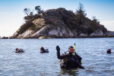 Horseshoe Bay, West Vancouver, British Columbia, Canada - Feb 29, 2020: Scuba Diver getting ready to go diving at Whytecliff Park during sunny winter day.