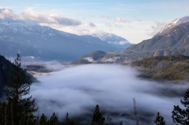 Kanada manzara manzarası bulutlu bir sabahta sisli vadiyi kapladı. Tantalus Gözcüleri 'nde çekildi. Squamish ve Whistler yakınlarında, Vancouver' ın kuzeyinde, BC, Kanada. Arkaplan