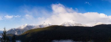Bulutlu bir sabahta Kanada 'nın panoramik manzarası Rocky Dağı Tepeleri. Tantalus Gözcüleri 'nde çekildi. Squamish ve Whistler yakınlarında, Vancouver' ın kuzeyinde, BC, Kanada. Arkaplan Panoraması