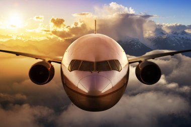 Renkli günbatımında ya da gündoğumunda bulutların üzerinde uçan uçak. Seyahat, ulaşım, havacılık, yolculuk, macera kavramı