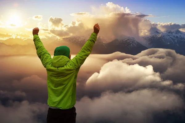 Adventurous friends on top of mountain with hands up during a colorful and vibrant sunset or sunrise. Composite. Concept: adventure, success, fun, explore, freedom, joy, excitement, fulfillment