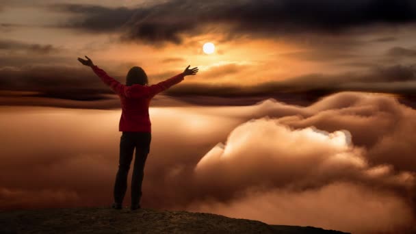 Cinemagraph of Girl on a Rocky Peak with clouds below — Wideo stockowe