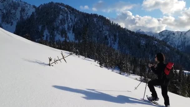 Kalandvágyó lány hótalpas a hóban egy hegy tetején — Stock videók