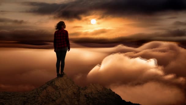 Cinemagraph de fille sur un pic rocheux avec des nuages en dessous — Video