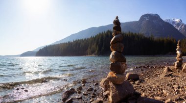 Güneşli bir kış gününde Alouette Gölü kıyısındaki kayalıklarda dengede durmak. Vancouver, British Columbia, Kanada yakınlarındaki Golden Ears Provincial Park 'ta çekilmiş. Panorama Arkaplanı