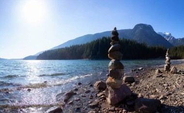 Güneşli bir kış gününde Alouette Gölü kıyısındaki kayalıklarda dengede durmak. Vancouver, British Columbia, Kanada yakınlarındaki Golden Ears Provincial Park 'ta çekilmiş. Panorama Arkaplanı