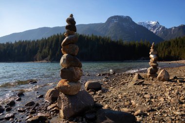 Güneşli bir kış gününde Alouette Gölü kıyısındaki kayalıklarda dengede durmak. Vancouver, British Columbia, Kanada yakınlarındaki Golden Ears İl Parkı 'nda çekildi..