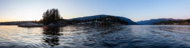Deep Cove, Kuzey Vancouver, British Columbia, Kanada. Renkli bir kış günbatımında Sudaki Evlerin Güzel Panoramik Manzarası. Panorama Arkaplanı