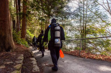 Horseshoe Bay, West Vancouver, British Columbia, Canada - Feb 29, 2020: Scuba Diver getting ready to go diving at Whytecliff Park during sunny winter day.