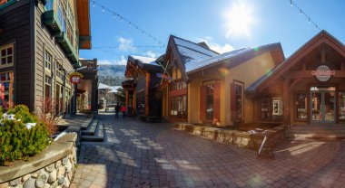 Whistler, British Columbia, Canada - March 11, 2020: Beautiful Panoramic View of Creekside Village on a small Touristic Ski Resort Town during a sunny winter morning. clipart