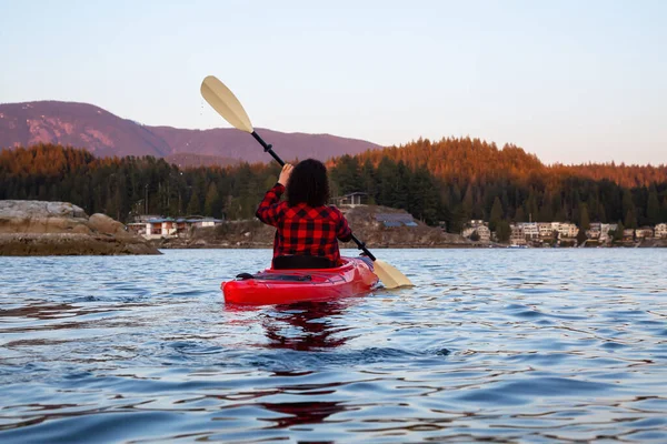 鮮やかでカラフルな夕日の間 穏やかな海の水の中で明るい赤カヤックを漕いで冒険的な女の子 インドアーム ディープコーブ ノースバンクーバー ブリティッシュコロンビア州 カナダで撮影 — ストック写真